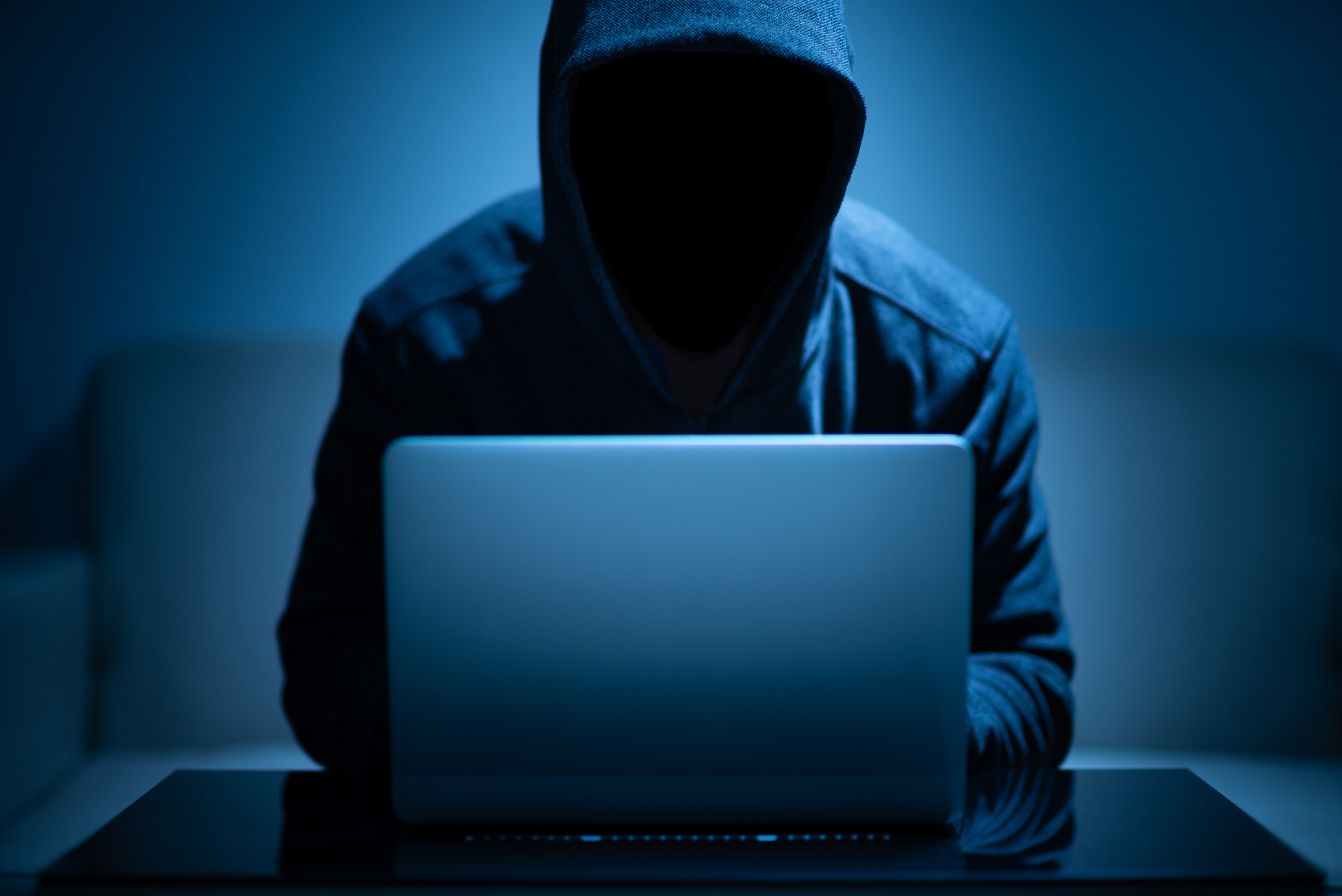 Hacker using laptop to commit a cybercrime. Denver IT Support can help you stay protected.